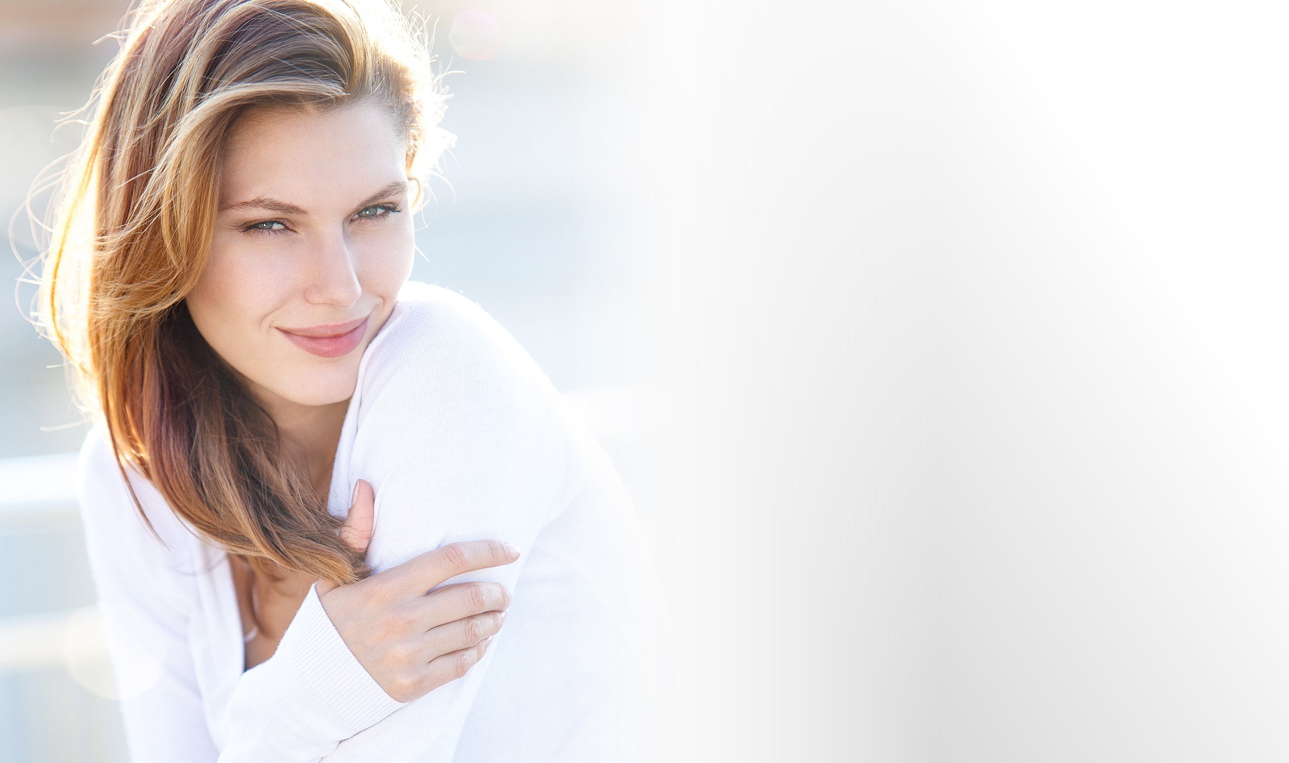 Smiling woman with long hair in white sweater