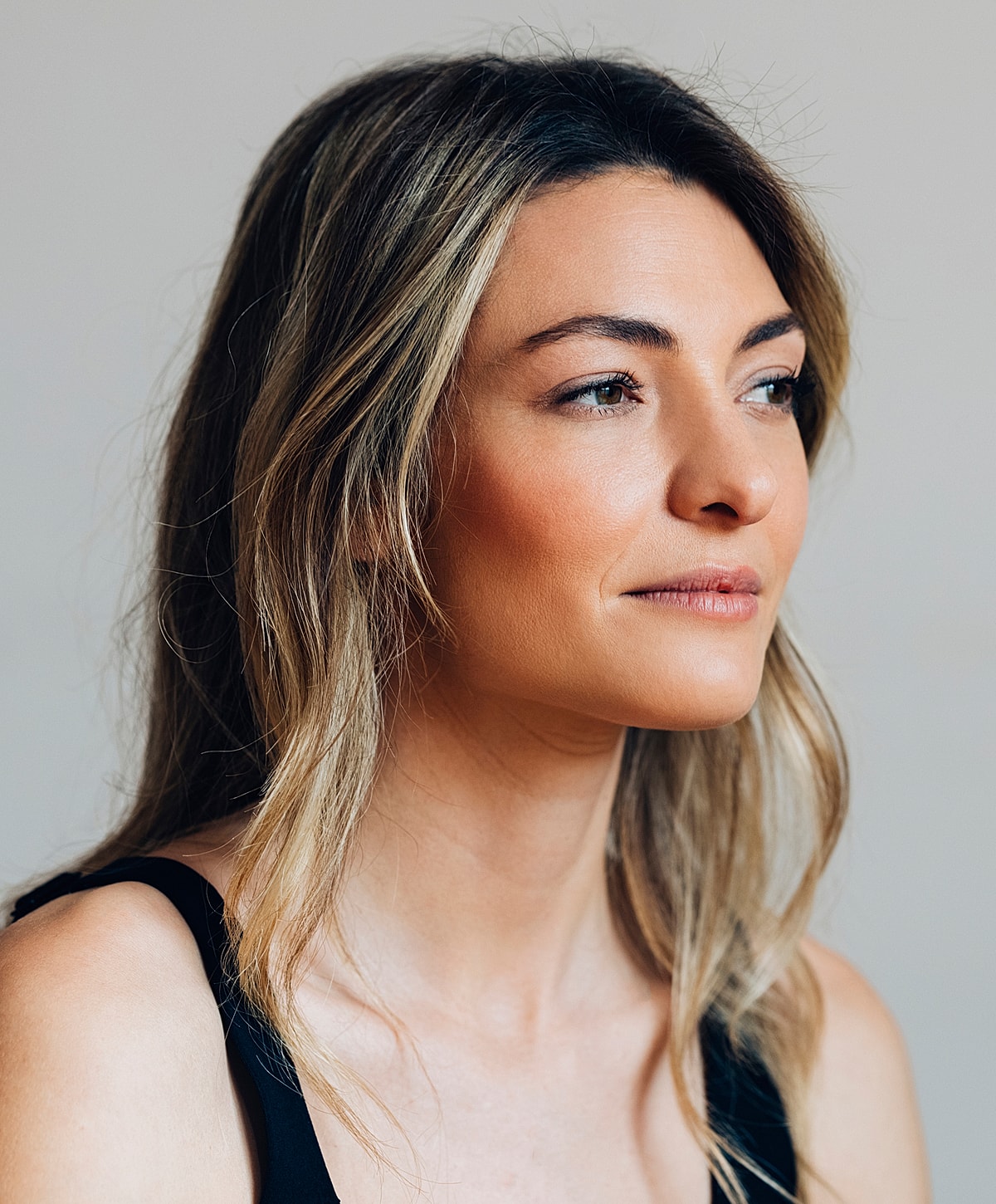 Woman with long hair looking thoughtfully to side.