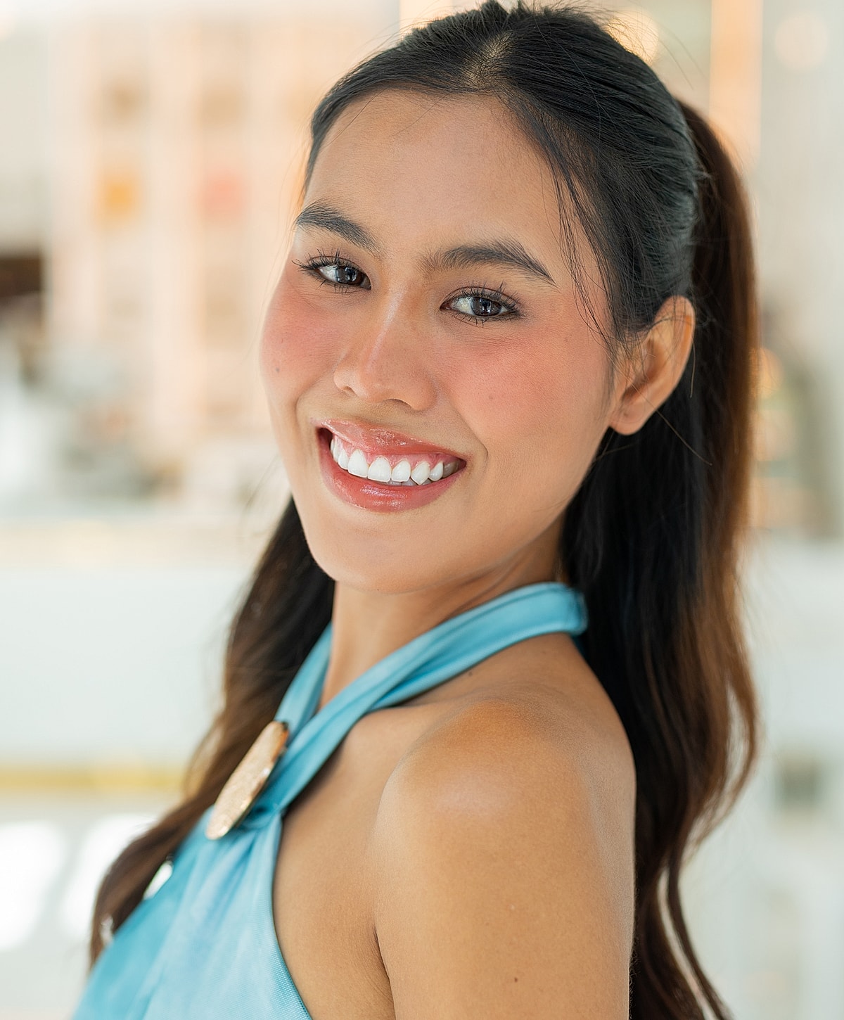 Smiling woman in a blue top background blurred.
