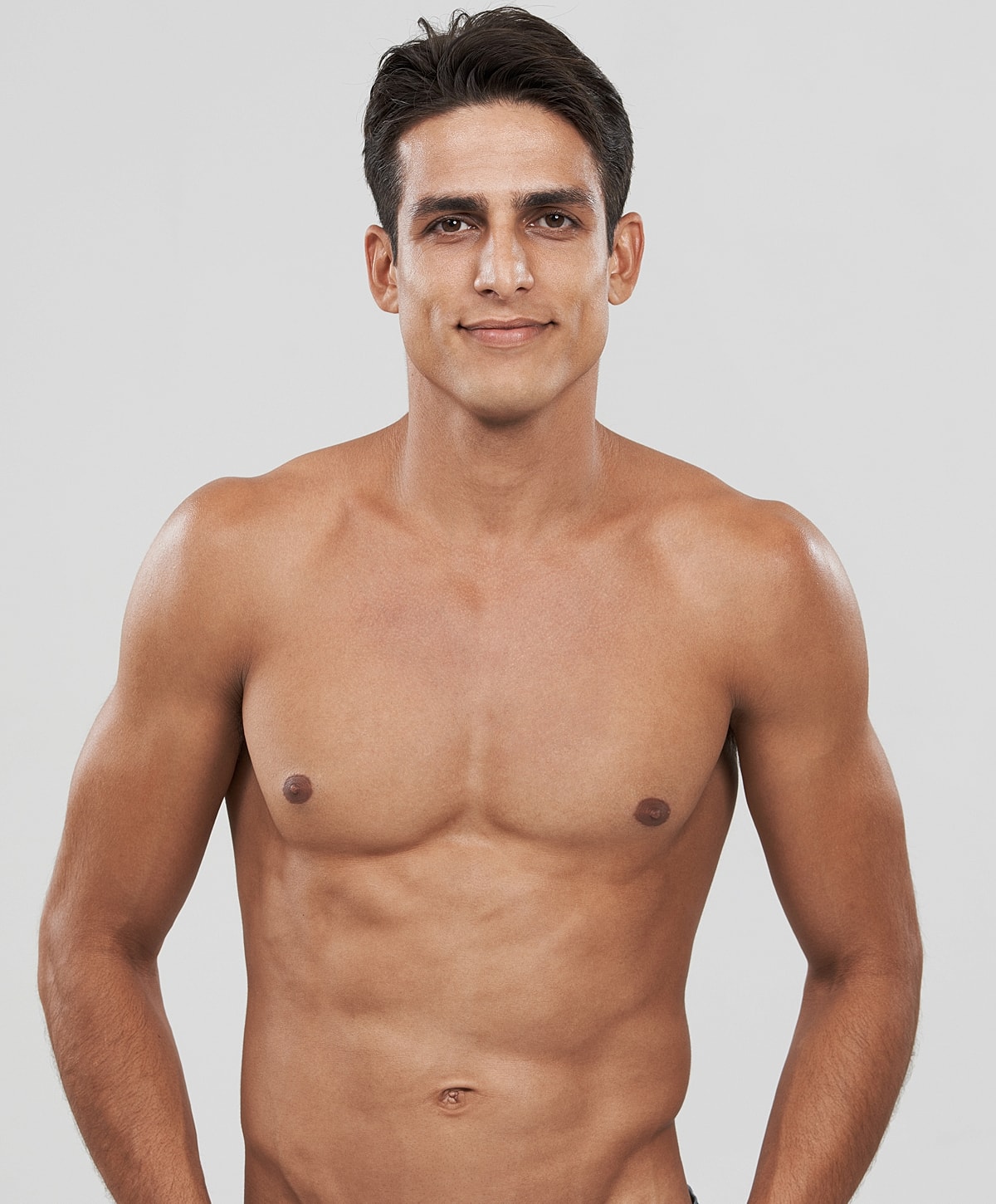 Athletic man smiling against a plain background.