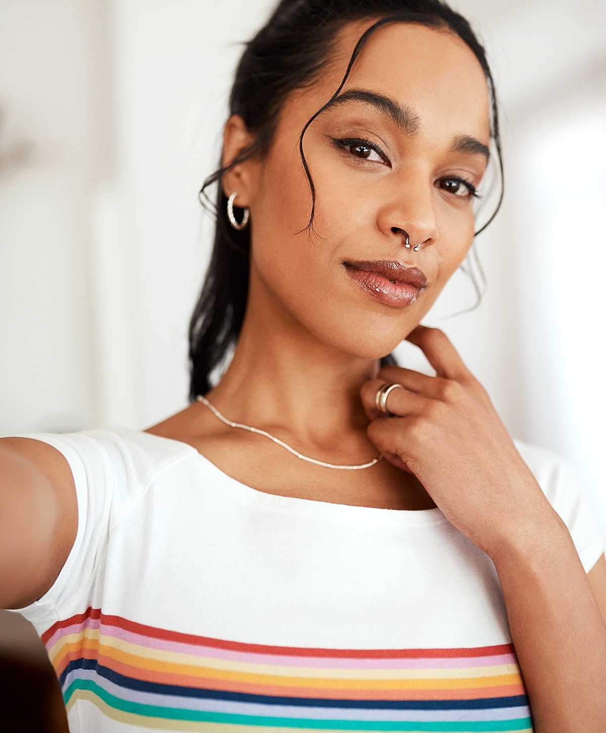 Person with curly hair in colorful striped shirt.