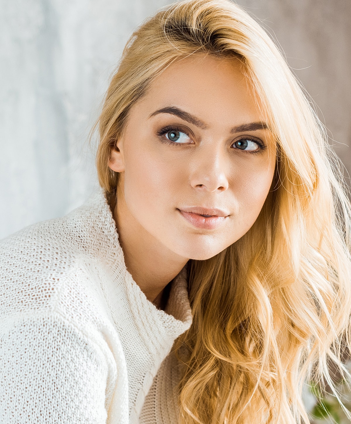Blonde woman in a cozy white sweater.