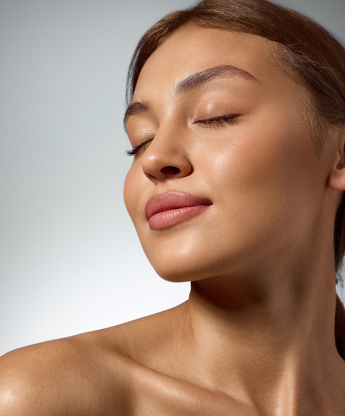 Woman with serene expression and glowing skin.