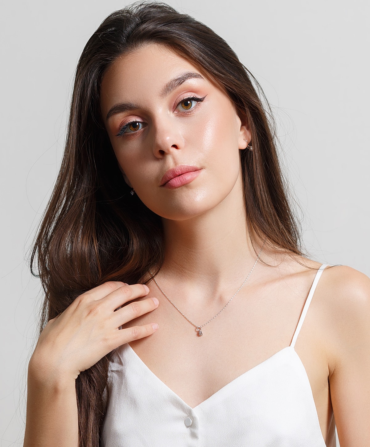 Model showcasing jewelry with elegant hairstyle.