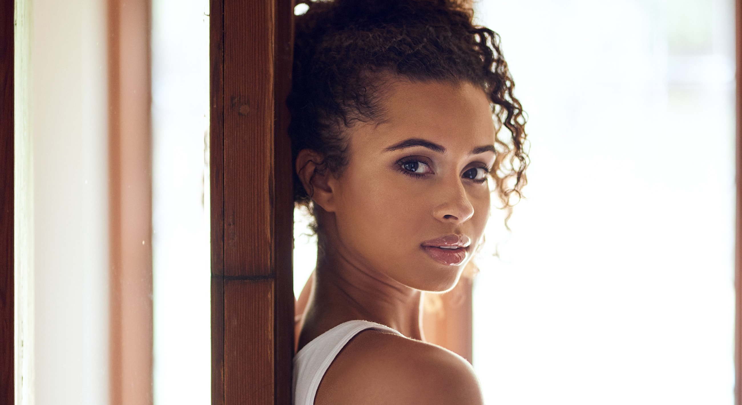 Woman with curly hair, natural lighting portrait.