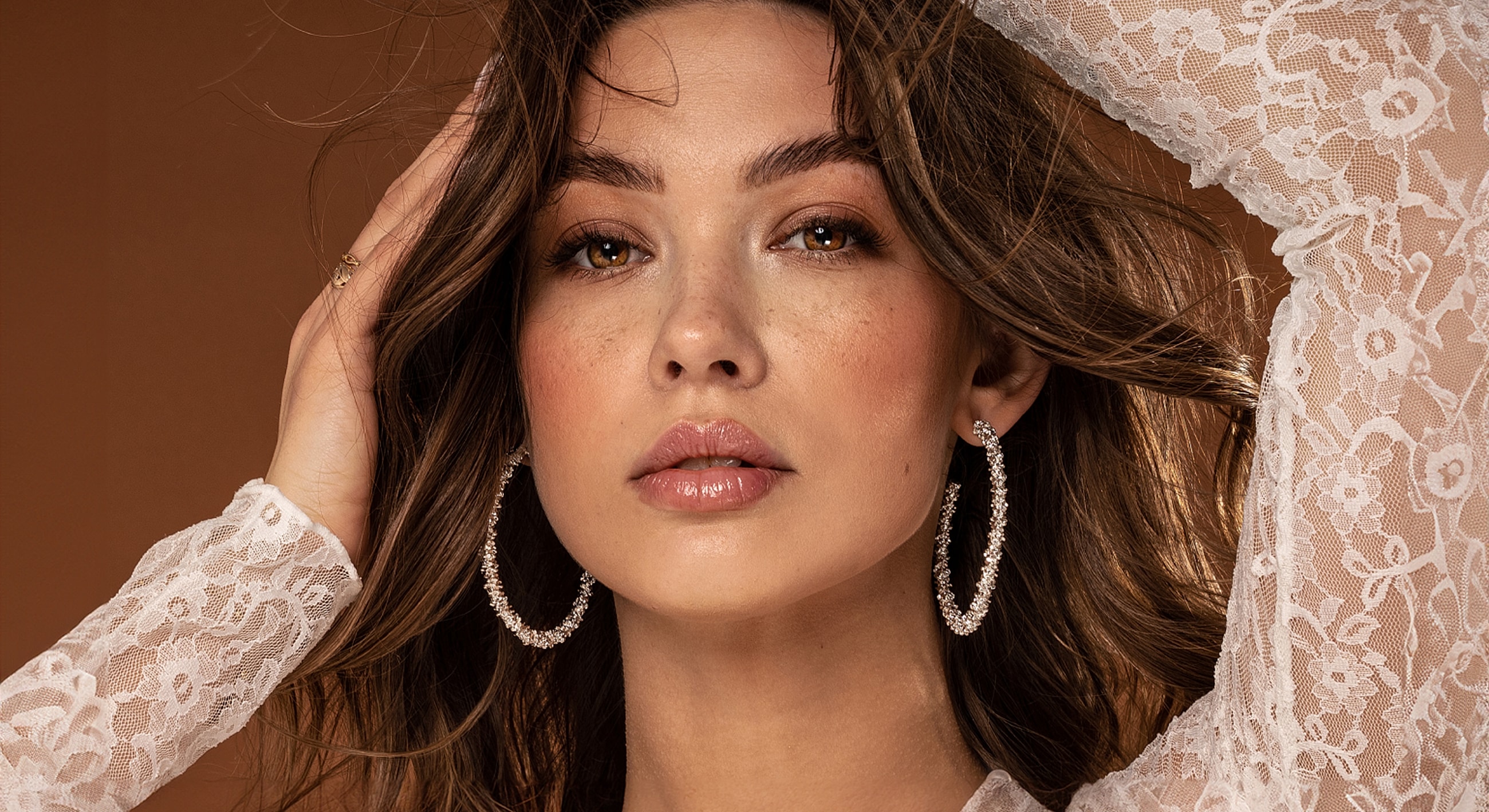 Model with lace top and elegant earrings.